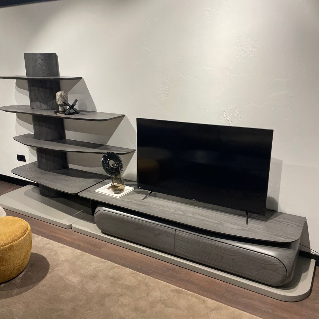 ТВ сет Moon с дълъг долен модул и горни елементи, подреден около телевизор в светла, модерна дневна.