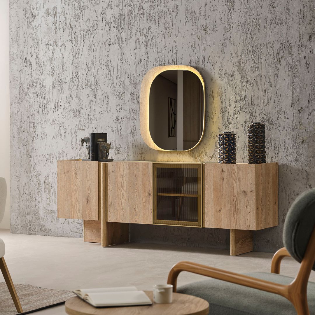 Бюфет Anka с огледало, заснет под ъгъл, с видими пропорции и повдигната конструкция. Мебелът изглежда лек и елегантен в пространството.