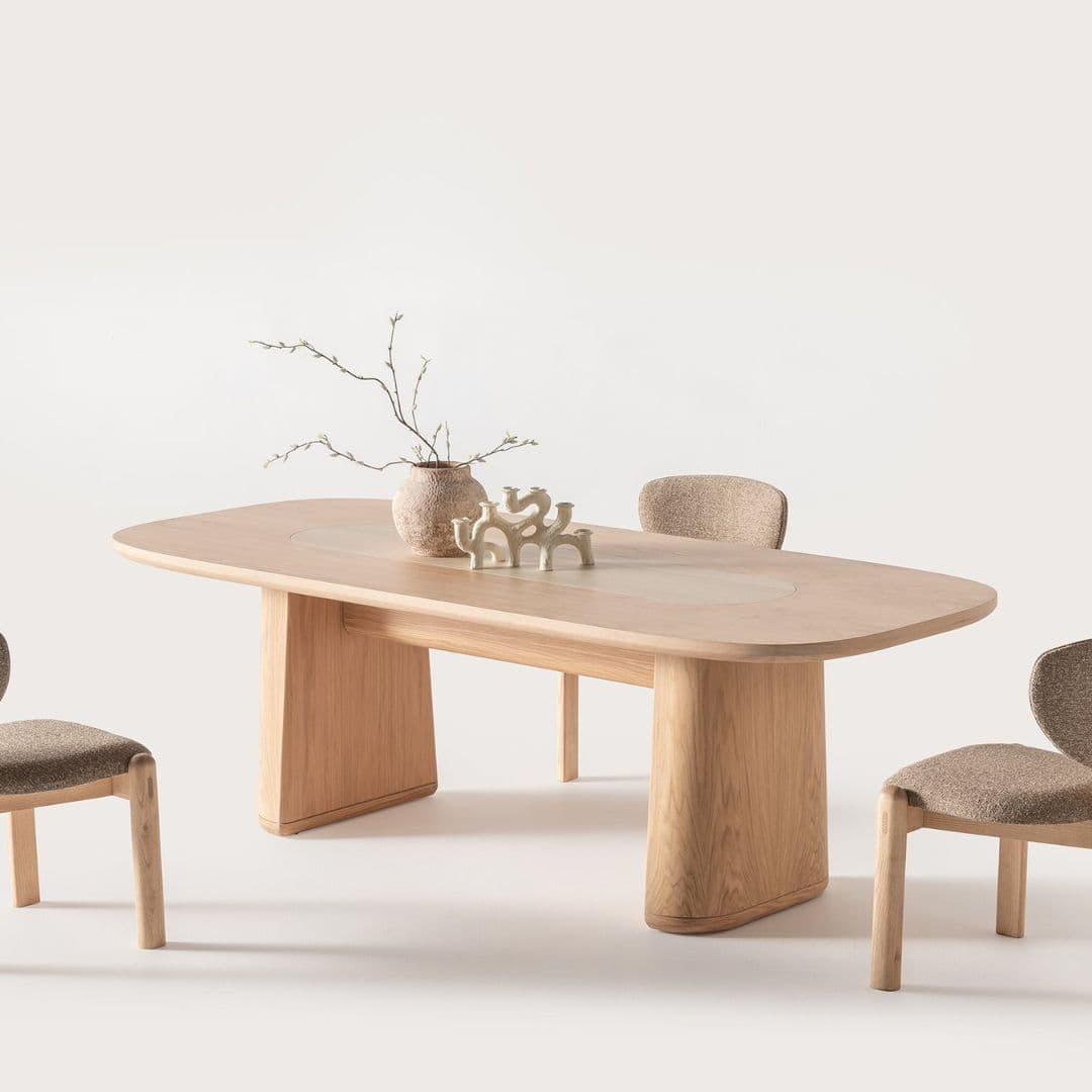 Трапезна маса Lumo, заснета под ъгъл, показваща правоъгълния плот и стабилните дървени крака с меки линии. 