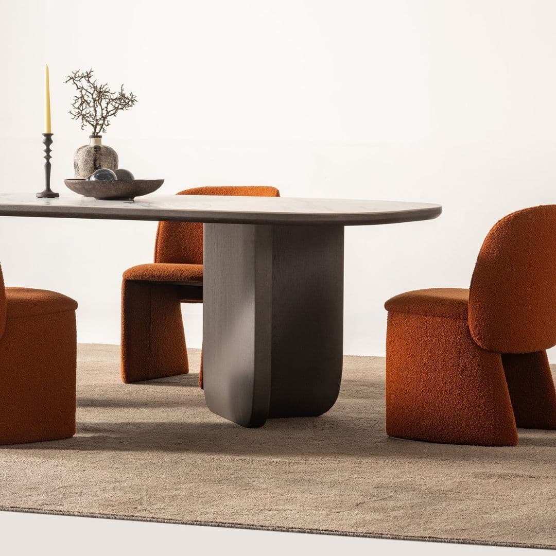 Трапезна маса Metropol, заснета под ъгъл, показваща елегантния овален плот и скулптурната централна основа.