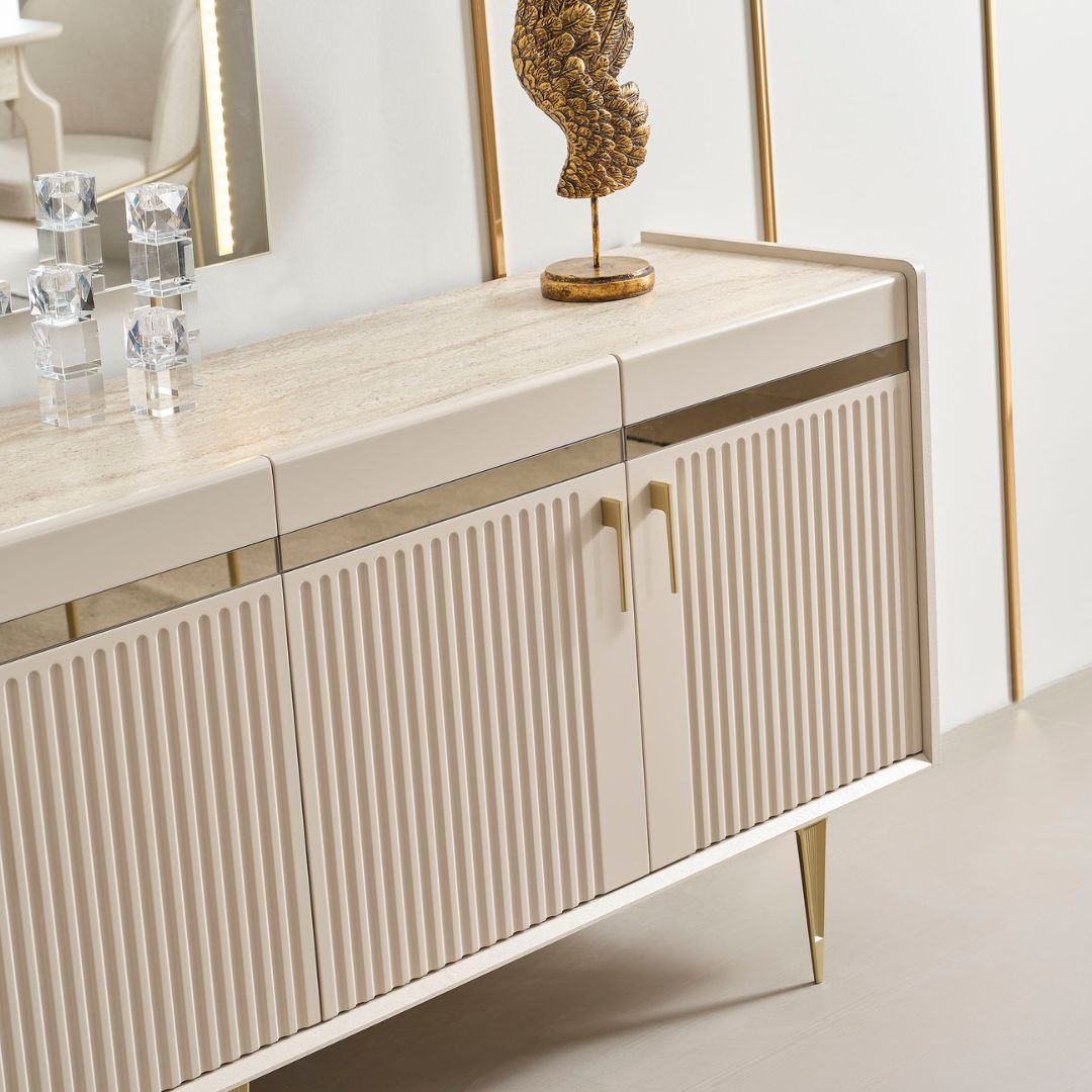 Бюфет Tesla – изглед три четвърти, който подчертава плавните ръбове и вертикалния релеф на вратите. Златистите детайли придават фин акцент.