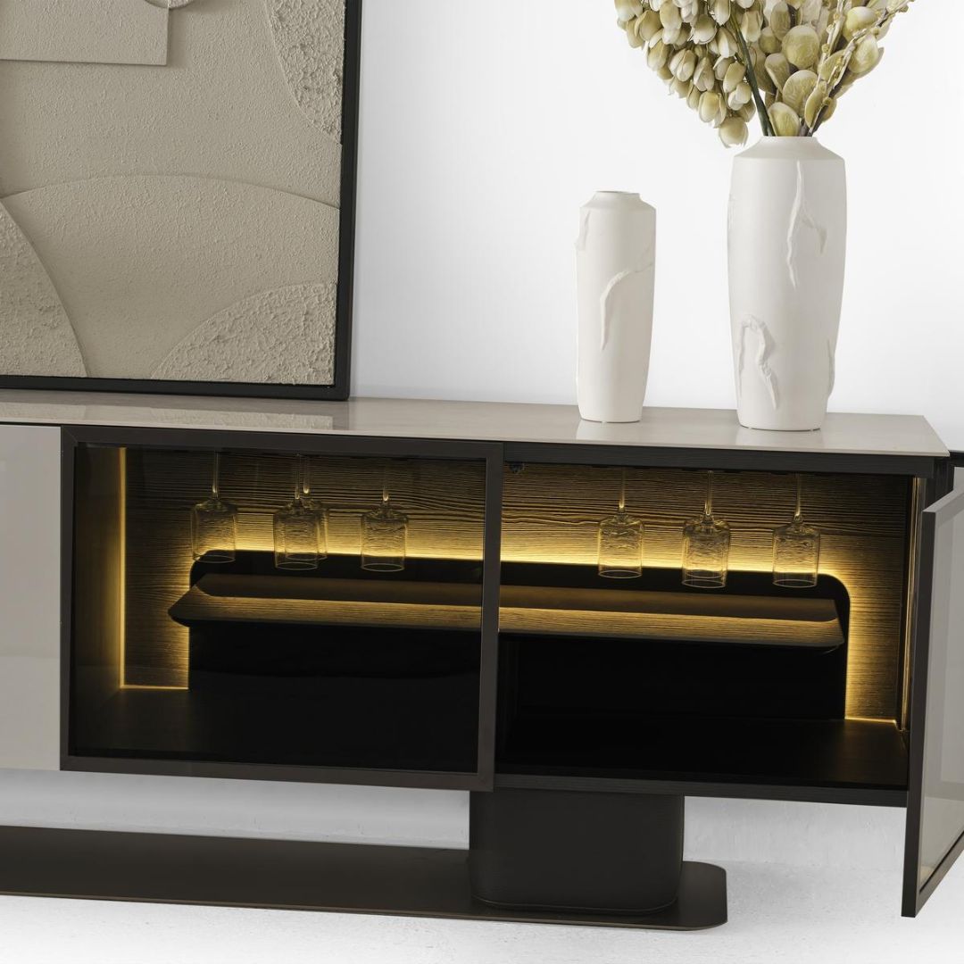 Близък план на горния плот на бюфет Moon A с подредени аксесоари и мека декоративна светлина.