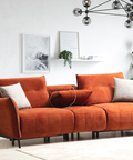 a living room with an orange couch and potted plants