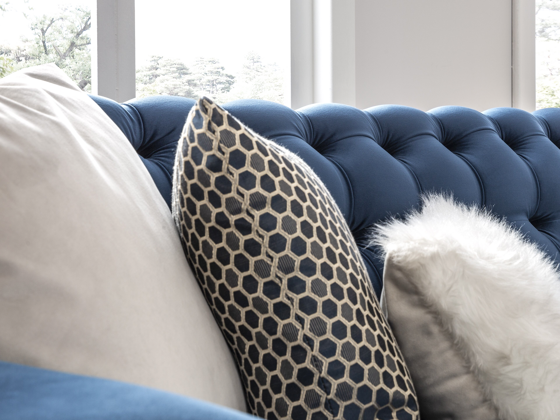 a blue couch with a white fluffy pillow