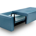 a blue couch with a pull out bed underneath it
