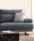 a gray couch sitting in a living room next to a table